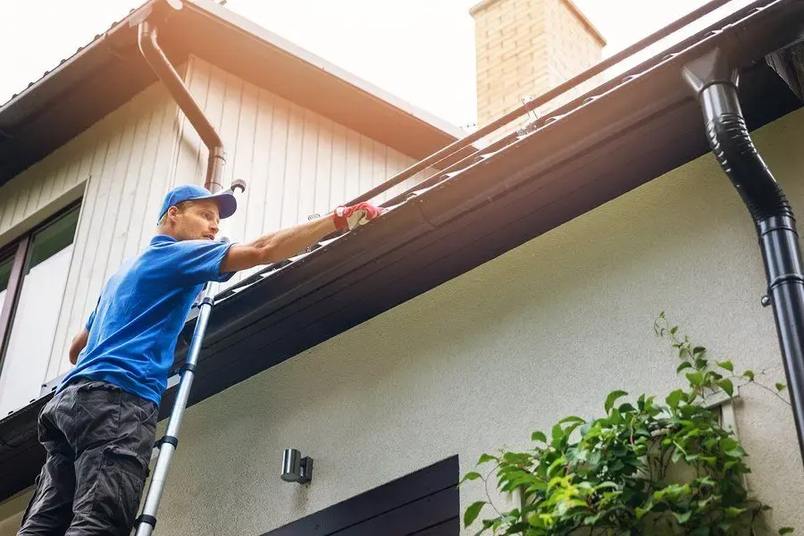 Clearing leaves from a clogged residential gutter