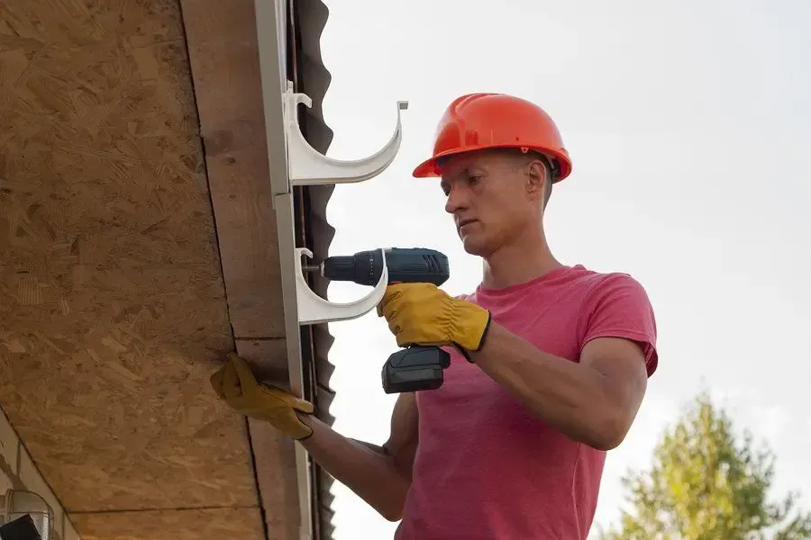 Clearing leaves from a clogged residential gutter